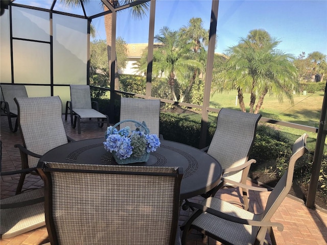 view of patio featuring glass enclosure and outdoor dining space