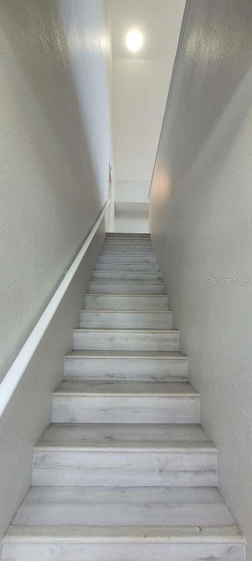 stairs featuring a textured wall