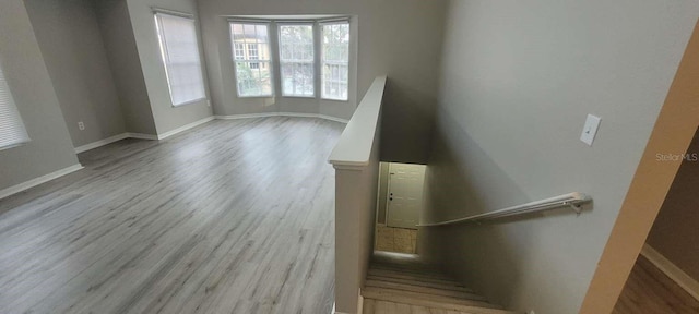 staircase with wood finished floors and baseboards