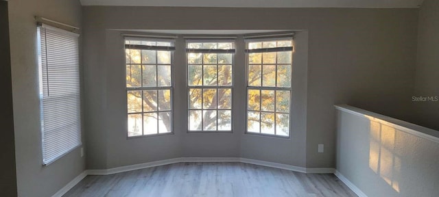 spare room featuring light wood-style flooring and baseboards