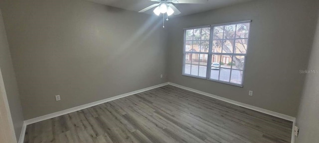 spare room featuring a ceiling fan, baseboards, and wood finished floors