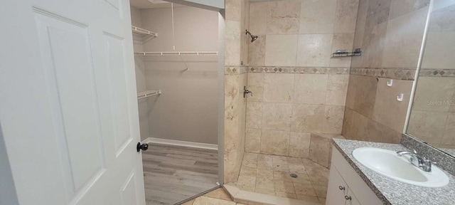 bathroom featuring a shower stall, a spacious closet, and vanity