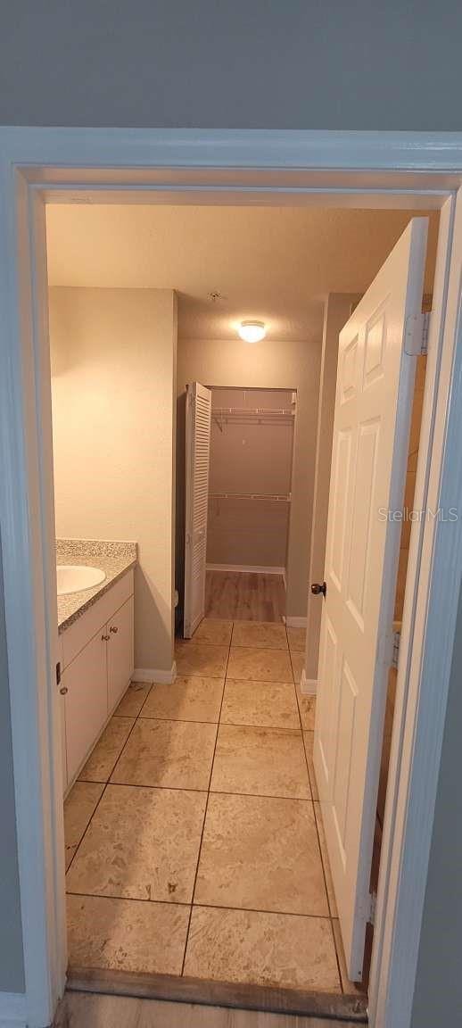 hallway with baseboards and light tile patterned floors