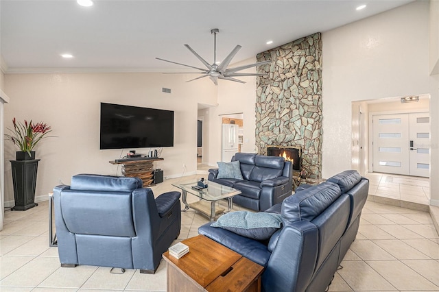 living room with ceiling fan, a fireplace, high vaulted ceiling, and light tile patterned flooring