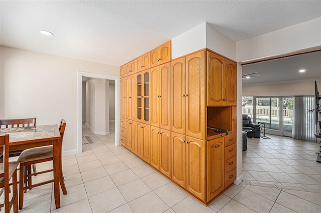 kitchen featuring recessed lighting, a textured ceiling, baseboards, and light tile patterned floors