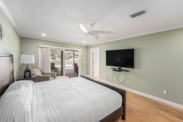 bedroom with baseboards, visible vents, wood finished floors, access to outside, and crown molding