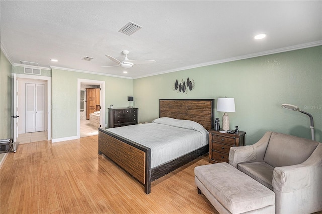 bedroom featuring ornamental molding, light wood-style flooring, visible vents, and baseboards