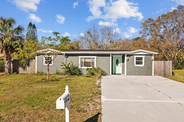 view of front facade with fence, a front lawn, and stucco siding