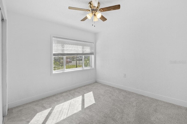 unfurnished room with light carpet, baseboards, and a ceiling fan