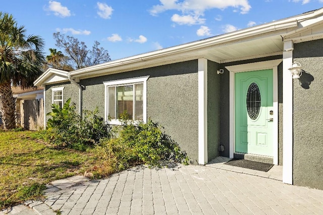 doorway to property featuring stucco siding