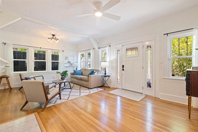 living room with baseboards, a healthy amount of sunlight, a ceiling fan, and light wood-style floors