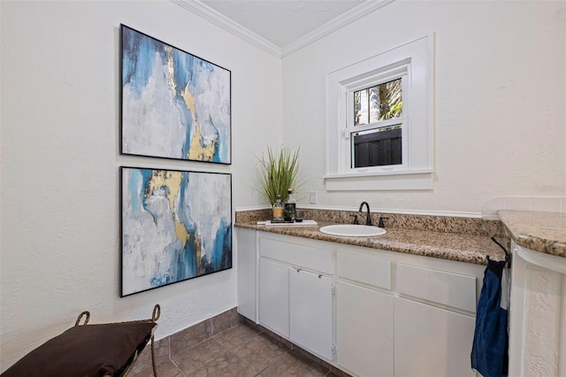 bathroom with a textured wall, ornamental molding, and vanity