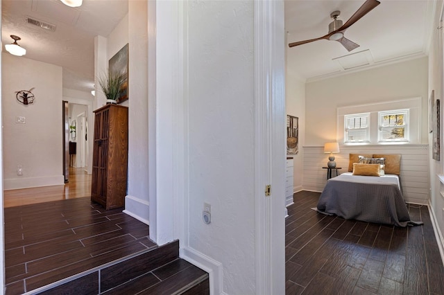 corridor featuring ornamental molding, wood finish floors, wainscoting, and visible vents