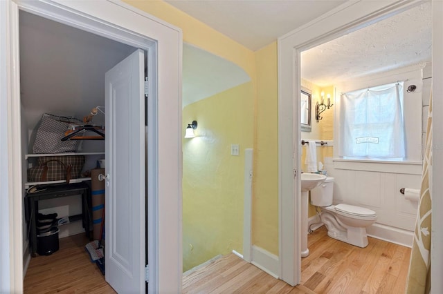 bathroom featuring wood finished floors and toilet