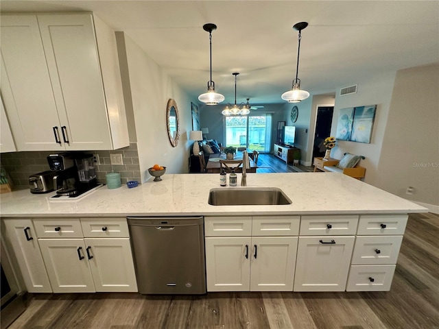 kitchen featuring dark wood finished floors, tasteful backsplash, visible vents, stainless steel dishwasher, and a sink