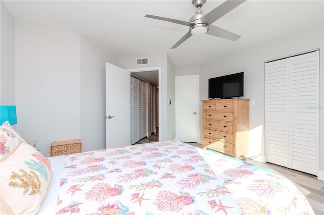 bedroom with a ceiling fan, visible vents, a closet, and wood finished floors