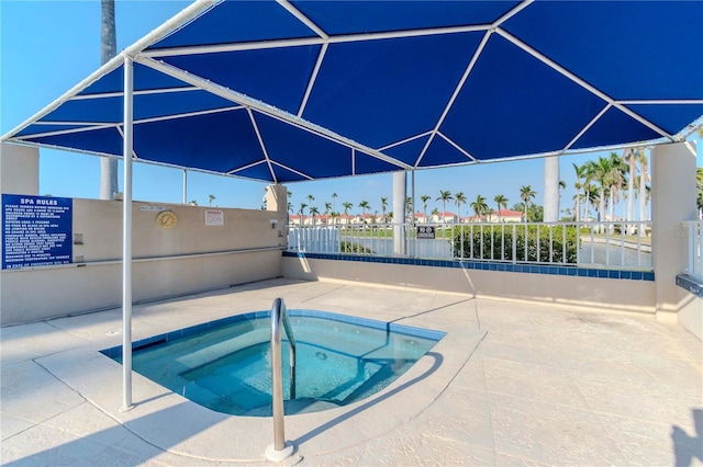 view of pool featuring a patio, a lanai, fence, and a hot tub