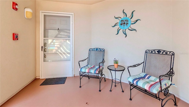 sitting room with concrete floors and baseboards