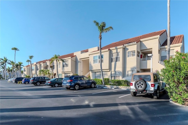 view of property with uncovered parking and a residential view