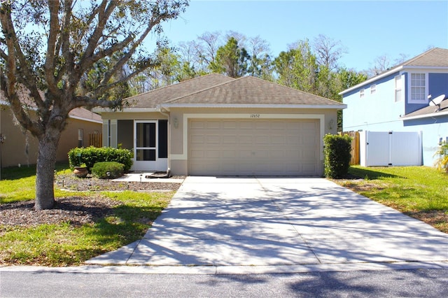 view of front facade featuring stucco siding, driveway, fence, roof with shingles, and an attached garage