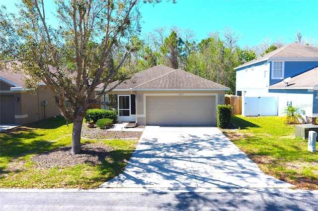 view of front of property featuring fence, concrete driveway, a front yard, stucco siding, and a garage