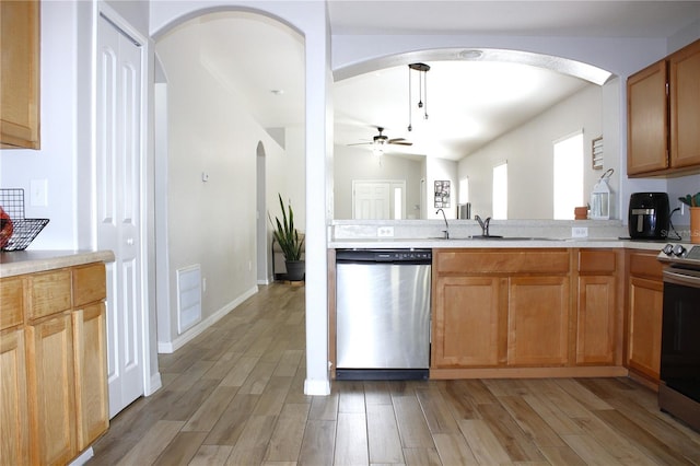 kitchen with light wood-style flooring, appliances with stainless steel finishes, light countertops, and a sink