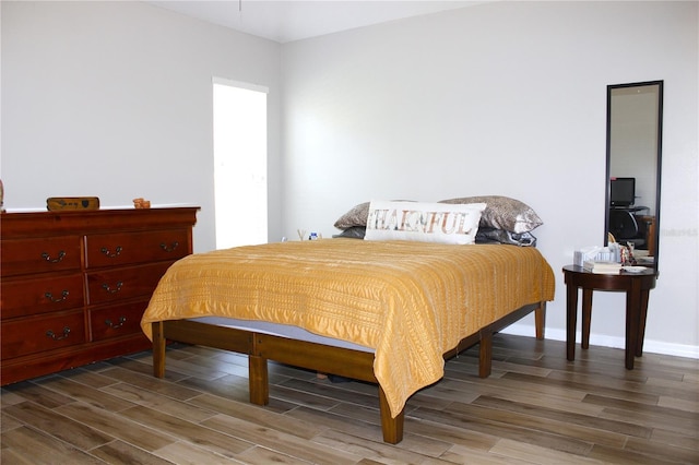 bedroom with baseboards and wood tiled floor