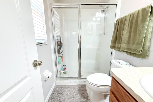 full bathroom with a shower stall, toilet, vanity, and baseboards