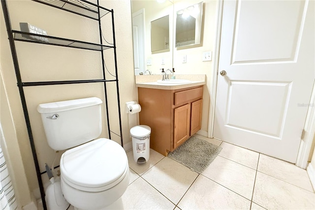 half bathroom featuring tile patterned floors, toilet, and vanity