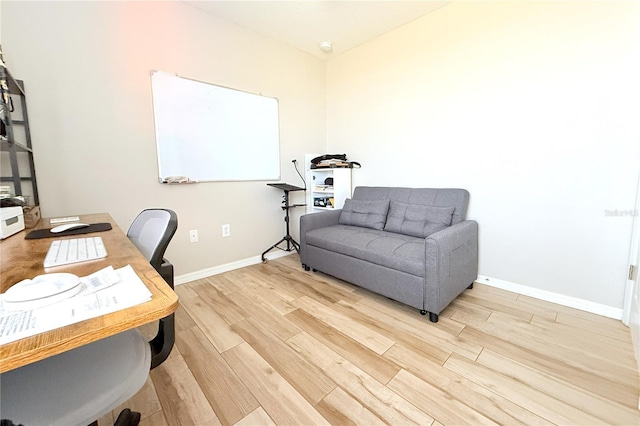 home office with light wood-type flooring and baseboards