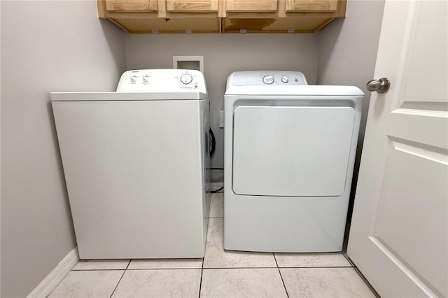 washroom featuring light tile patterned flooring, cabinet space, and independent washer and dryer