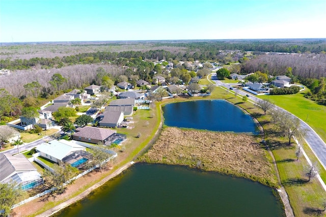 birds eye view of property featuring a residential view, a water view, and a wooded view