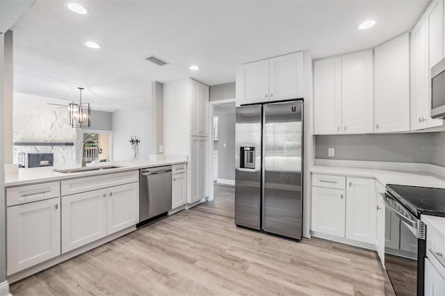 kitchen with white cabinets, visible vents, appliances with stainless steel finishes, and a sink