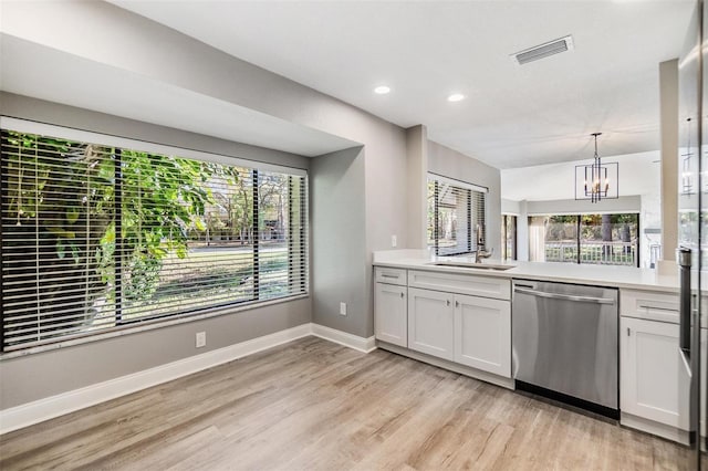 kitchen featuring a wealth of natural light, dishwasher, and light countertops