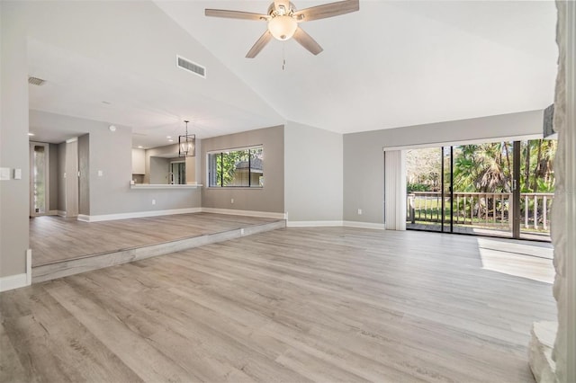 unfurnished living room featuring visible vents, baseboards, light wood-type flooring, ceiling fan with notable chandelier, and high vaulted ceiling