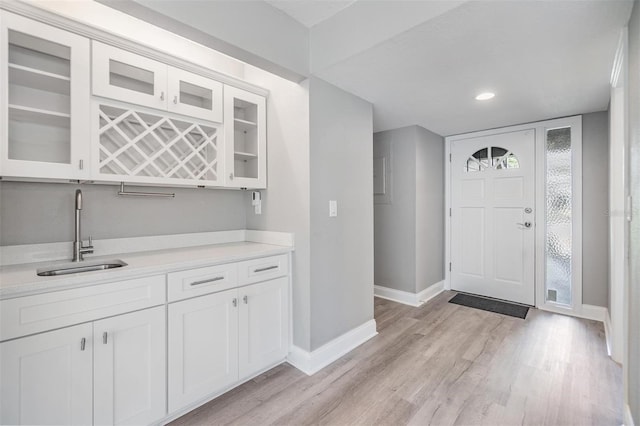 foyer featuring wet bar, recessed lighting, baseboards, and light wood-type flooring