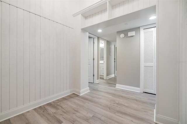 corridor with baseboards and wood finished floors