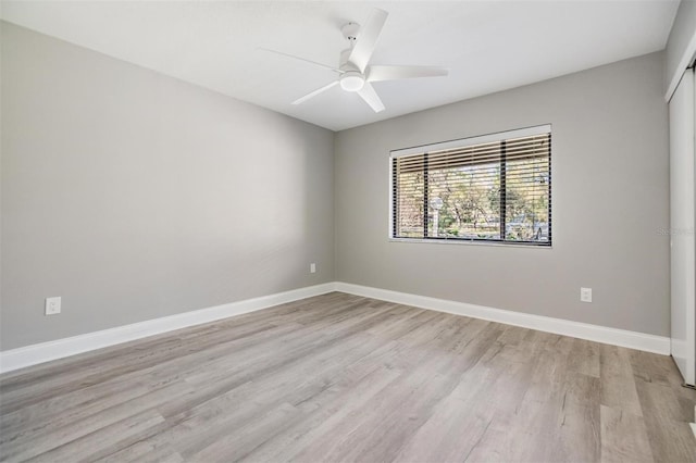 empty room featuring ceiling fan, baseboards, and light wood-type flooring