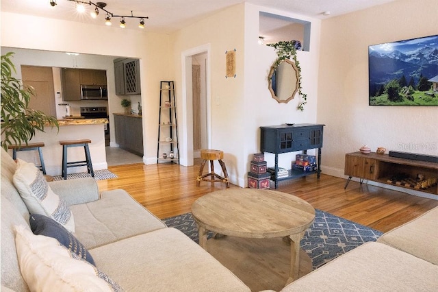 living area featuring baseboards and light wood finished floors