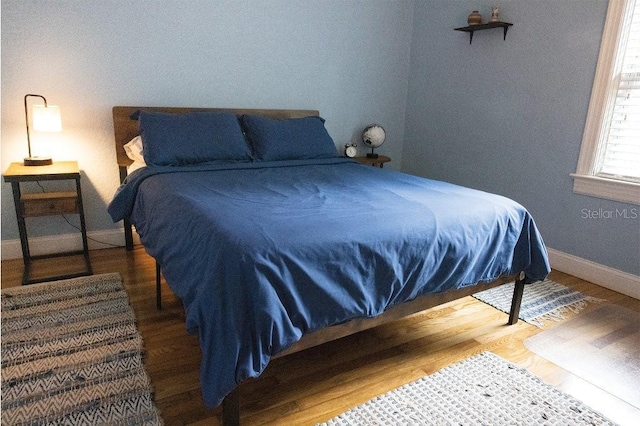 bedroom featuring wood finished floors and baseboards