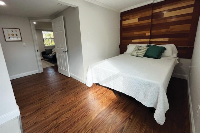 bedroom featuring ornamental molding, baseboards, and wood finished floors