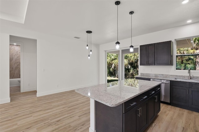 kitchen featuring dishwasher, light wood finished floors, a sink, and a healthy amount of sunlight