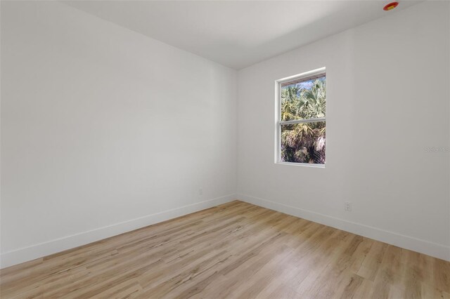 unfurnished room featuring light wood-type flooring and baseboards