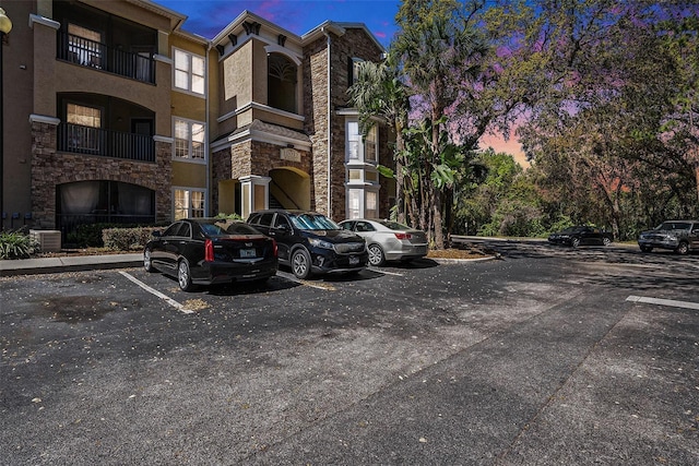 view of property with uncovered parking and cooling unit