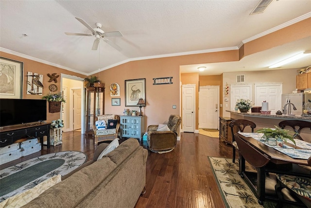 living room with lofted ceiling, ornamental molding, dark wood finished floors, and visible vents