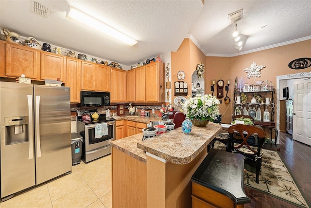 kitchen featuring crown molding, a breakfast bar area, stainless steel appliances, and light countertops