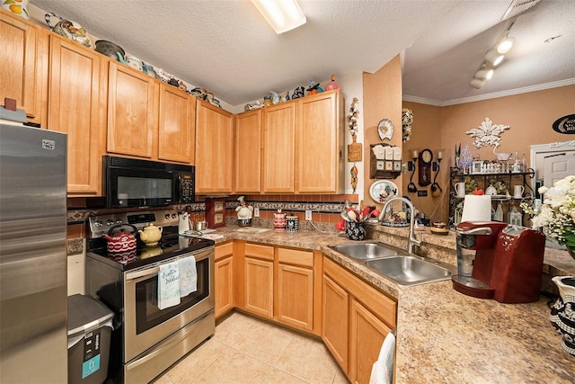 kitchen with light tile patterned floors, appliances with stainless steel finishes, a textured ceiling, and a sink