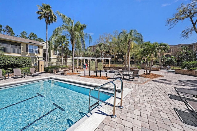 pool with a patio and fence