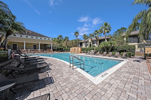 community pool featuring fence and a patio