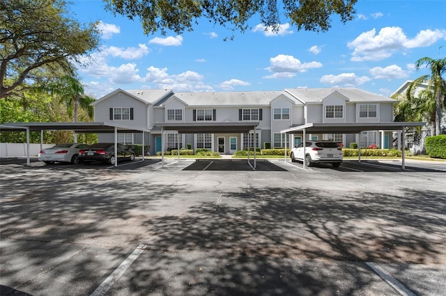 view of property featuring covered and uncovered parking